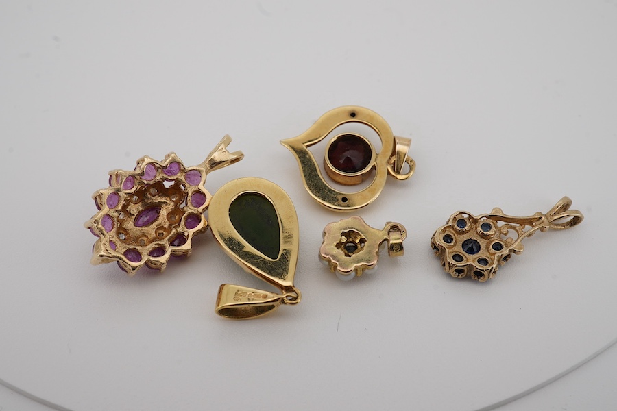 A modern 9ct gold and pear shaped nephrite set pendant, overall 25mm, a similar 9ct gold and garnet set pendant and three other gem set pendants, including 9ct and two unmarked. Condition - fair to good